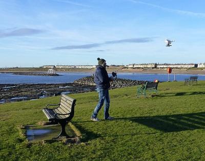 A drone enthusiast watches his craft take flight. (Photo: Russel Wills, CC BY-SA 2.0, via Wikimedia Commons)