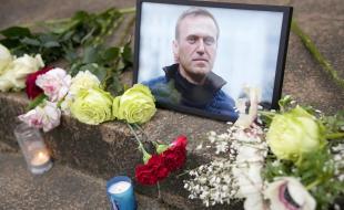 Flowers and candles are placed near a portrait of Russian opposition leader Alexei Navalny. (Photo via X.)