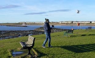 A drone enthusiast watches his craft take flight. (Photo: Russel Wills, CC BY-SA 2.0, via Wikimedia Commons)